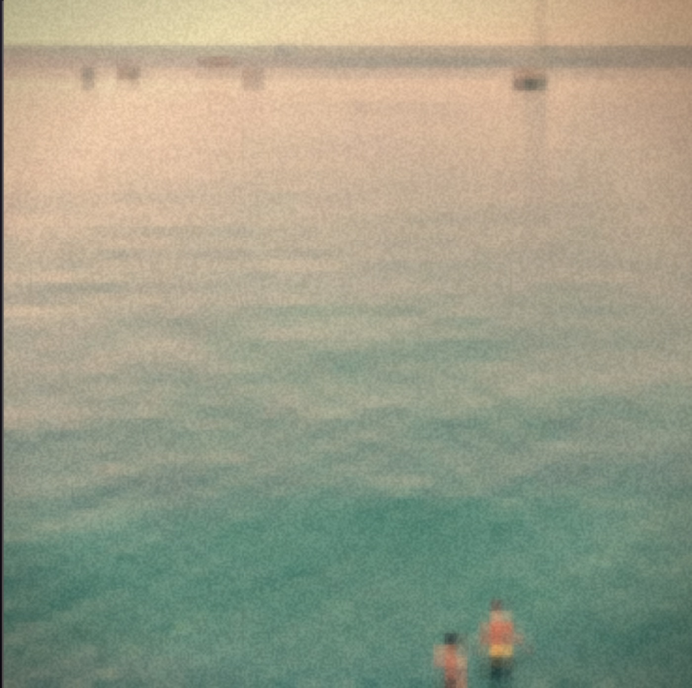 Adrift — a warm faded sea dissolving into grain